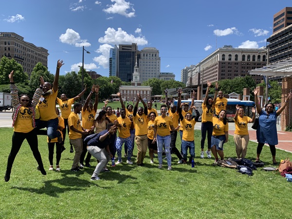 Mandela Fellows jumping in the air, wearing gold Drexel t-shirts in front of Independence Hall